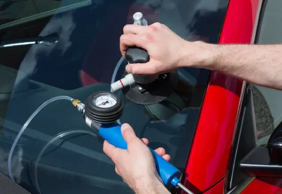 a person using a pressure gauge to fix a windshield