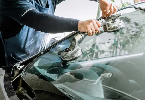 a person holding a suction cup over a windshield