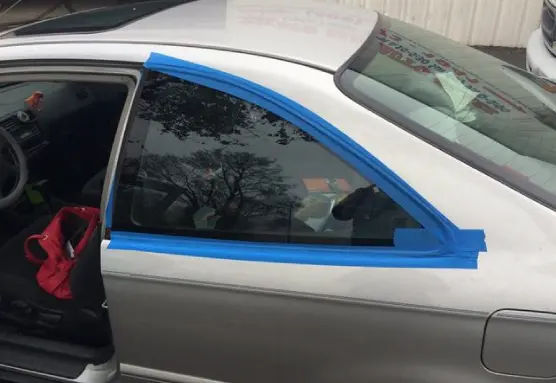 a car with blue tape on the rear window