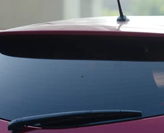 A close-up of a red car's rear windshield